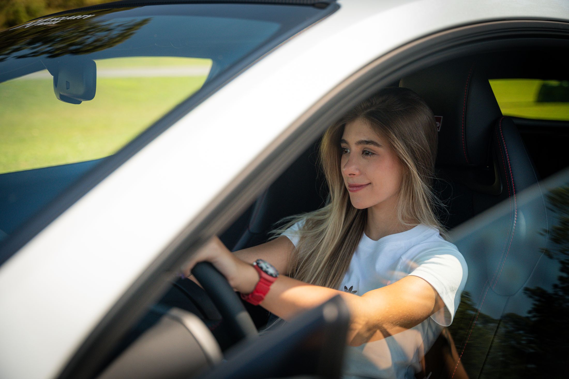 Valentina Piaz at the wheel, smiling, sunlight across her arm